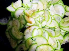 放入西葫芦翻炒1分钟，倒入生抽翻炒，加青椒炒至有水份