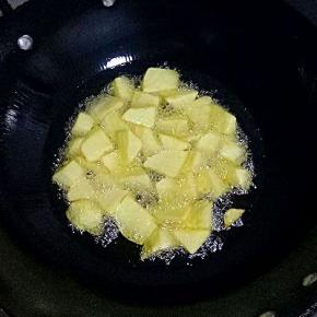 锅里倒油放入土豆块炸至金黄捞出