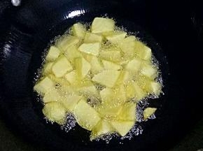 锅里倒油放入土豆块炸至金黄捞出