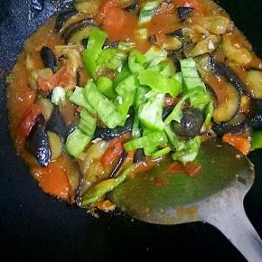 加少许水，倒入茄子翻炒，加入生抽，盐，青椒翻炒