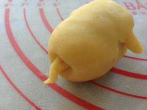 将猪屁股向里压按一下，然后用小小的面团搓长，沾点水，粘在猪屁股上面。