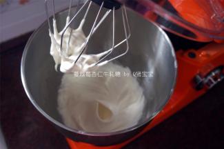 70克蛋白霜粉加入70克冷开水搅打至干性发泡状态。（注意，糖浆熬至100度开始这步制作）