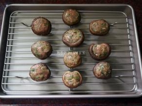 在菌盖中酿入肉馅，放在烤网上。