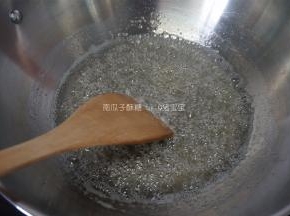 中小火熬煮糖浆，细砂糖完全融化后开始搅拌，糖浆熬至145度熄火。