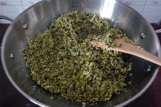 将保温中的芝麻南瓜子全部倒入糖浆中，翻炒均匀。