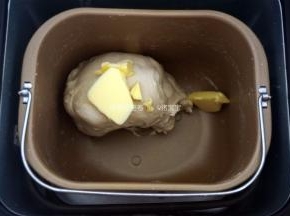 将高筋粉300克、细砂糖25克、奶粉15克、酵母4克、盐3克、全蛋液15克、清水180克，按照先液体后固体的顺序放入面包机，启动揉面程序。本次使用的是柏翠PE8500W面包机的IMix程序。揉至程序结束，放入20克黄油。