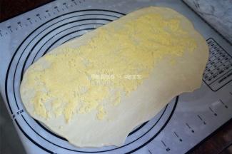 将椰蓉馅料均匀放入，注意收口端不用放置馅料，卷起，分成6份（两个面团共分成12份）。