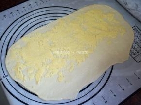 将椰蓉馅料均匀放入，注意收口端不用放置馅料，卷起，分成6份（两个面团共分成12份）。