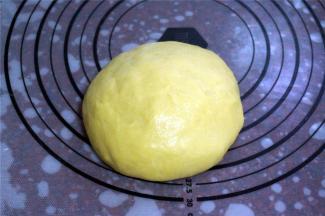 取出搅拌刀，将面团揉圆，重新放入面包桶里。