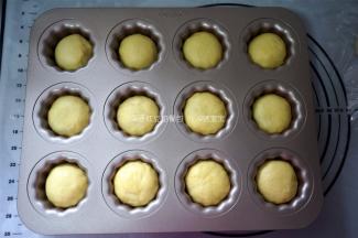 捏紧收口，滚圆，收口朝下放入可露丽12连模中，放温暖处进行二次发酵。