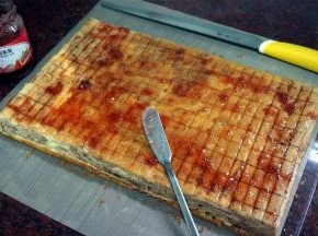 每隔两厘米划一刀浅痕，抹上草莓果酱。