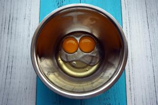 将两个蛋黄，玉米油，清水同放入打蛋盆中，搅拌均匀。