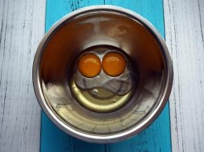 将两个蛋黄，玉米油，清水同放入打蛋盆中，搅拌均匀。