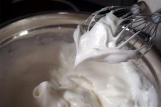 5个蛋白加入0.5小茶匙食盐，分3次加入细砂糖，打发至湿性发泡状态。