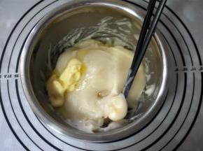 取出蒸熟的麻薯面团，冷却至微温状态时加入20克黄油，揉成光滑的麻薯面团。