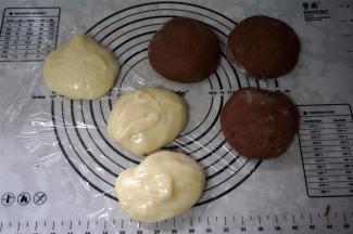 取出可可面团，排气。将麻薯面团及可可面团分别分成三等份，盖上保鲜膜，松弛10分钟。