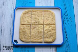 在烤火腿肠的过程中，将披萨皮切成6份，放入模具。