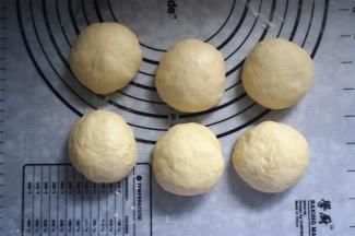 取出面团，排气后分成6等份，揉圆，盖上保鲜膜静置松弛15分钟。