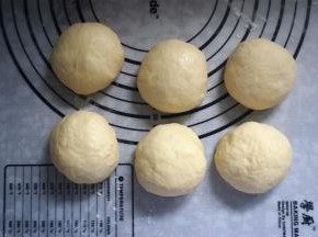 取出面团，排气后分成6等份，揉圆，盖上保鲜膜静置松弛15分钟。