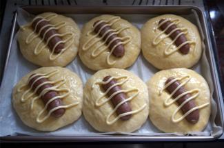 面团二次发酵结束后，在表面刷上一层全蛋液，在中间放一条火腿肠，然后挤上沙拉酱。