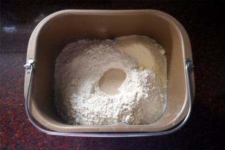 将黄油除外的食材按照先液体后固体的顺序放入面包机，启动揉面程序揉面20分钟。