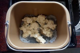 将黄油除外的主面团的食材按照先液体后固体的顺序放入面包机，然后放入撕碎了的中种面团，揉面20分钟。
