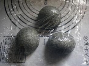 取出发酵完毕的面团排气后平均分成3份，滚圆，盖上保鲜膜，松弛15分钟。