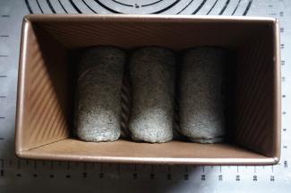 将面团擀开，卷起，排入450克的吐司盒中。