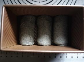 将面团擀开，卷起，排入450克的吐司盒中。