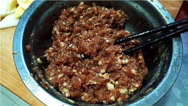 猪肉馅中加入料酒、油、盐、胡椒粉、葱姜，搅拌均匀上劲。
