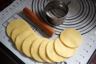 将面团擀开成0.5厘米厚的面片，用饺子皮模具印出直径8厘米左右的圆形面片。