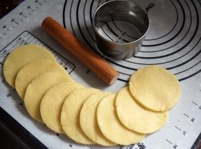 将面团擀开成0.5厘米厚的面片，用饺子皮模具印出直径8厘米左右的圆形面片。