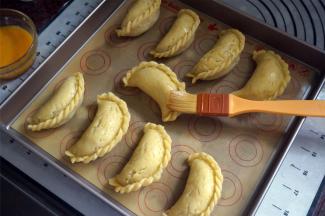 将酥角放入烤盘，表面刷上一层全蛋液。