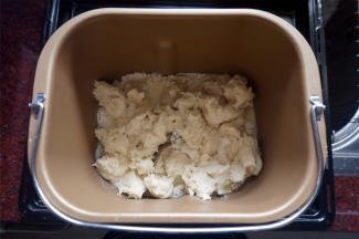 将黄油除外的主面团食材（主面团：高筋粉80克、牛奶33克、细砂糖27克、盐4克、全蛋液27克、炼奶40克、黄油21克、 酵母1克）按照先液体后固体的顺序放入面包机里，然后将发酵好的中种面团撕成小块放入，启动揉面程序，时间20分钟。