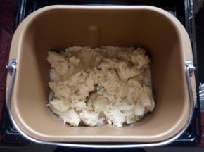 将黄油除外的主面团食材（主面团：高筋粉80克、牛奶33克、细砂糖27克、盐4克、全蛋液27克、炼奶40克、黄油21克、 酵母1克）按照先液体后固体的顺序放入面包机里，然后将发酵好的中种面团撕成小块放入，启动揉面程序，时间20分钟。