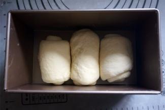 将面团擀开，然后卷起，排放入吐司盒中。