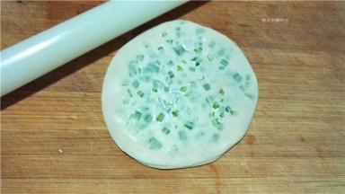 用擀面杖将饼皮擀成又大又圆的一片。