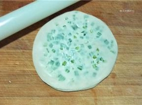 用擀面杖将饼皮擀成又大又圆的一片。