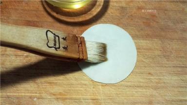 取一张饺子皮，刷上植物油。