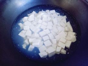 锅中加入清水，大火烧开，下切好的豆腐焯水。倒入豆腐后烧烤捞出即可