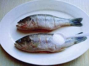 将洗干净的鱼放在鱼盘里，撒上盐。