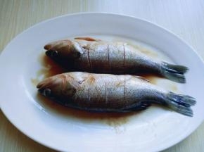 把鱼翻个面，使两条鱼均匀的粘上腌料，腌制15分钟。