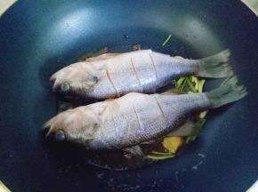 再把腌制好的鱼放进锅里，中火将鱼煎至两面微黄。