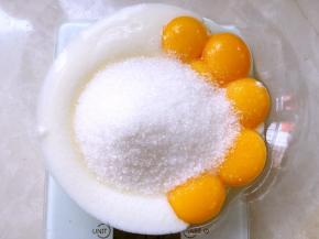 分离鸡蛋，蛋白打至干净容器，蛋黄加60克砂糖跟酸奶搅拌均匀