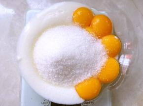 分离鸡蛋，蛋白打至干净容器，蛋黄加60克砂糖跟酸奶搅拌均匀