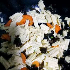 放入腐竹，木耳翻炒几下，放适量生抽，盐，加少许水翻炒二分钟左右