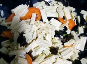 放入腐竹，木耳翻炒几下，放适量生抽，盐，加少许水翻炒二分钟左右