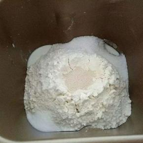 首先把牛奶和鸡蛋放入面包机内，在放入高筋面粉，酵母放中间，盐和糖对角线放，然后启动和面程序（默认20分钟）