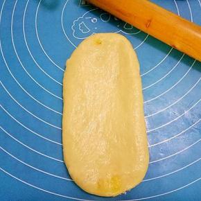 将包入椰蓉馅的面团擀成长圆形