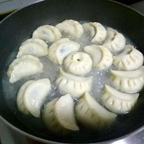 小火煎制3分钟，倒入清水，没过饺子三分之一，改成中小火，盖上锅盖，焖3分钟